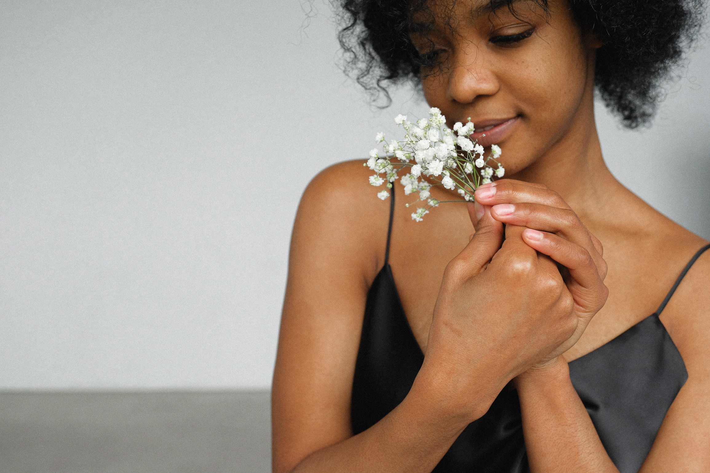 Woman in Black Tank Top Holding Baby's Breath flowers